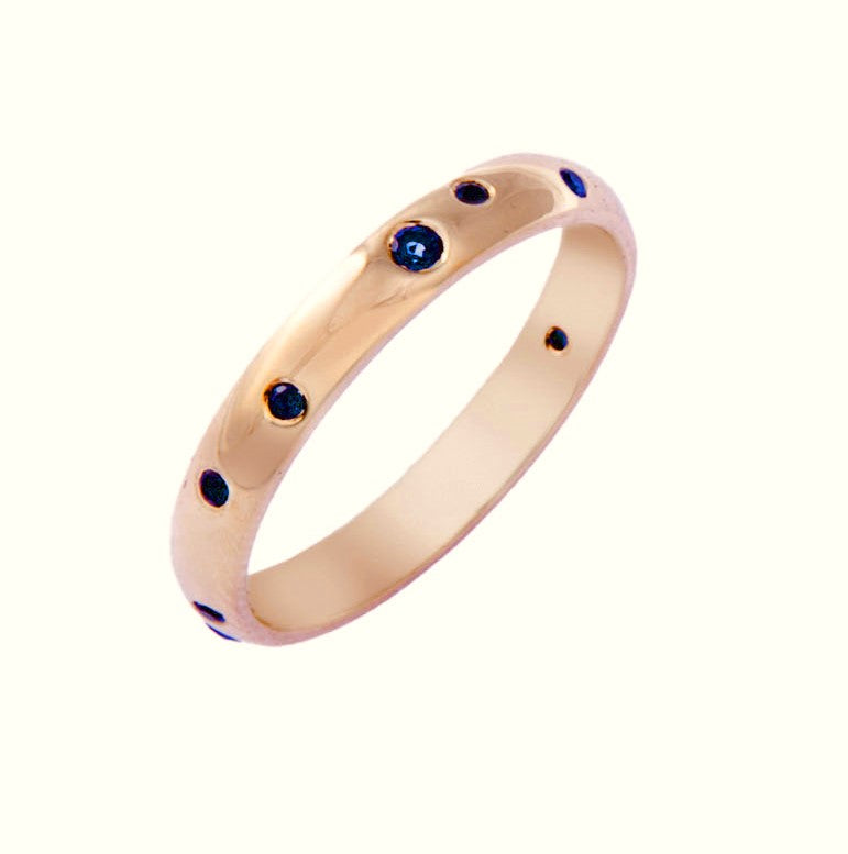 Yellow gold wedding ring with blue sapphires set randomly around the surface