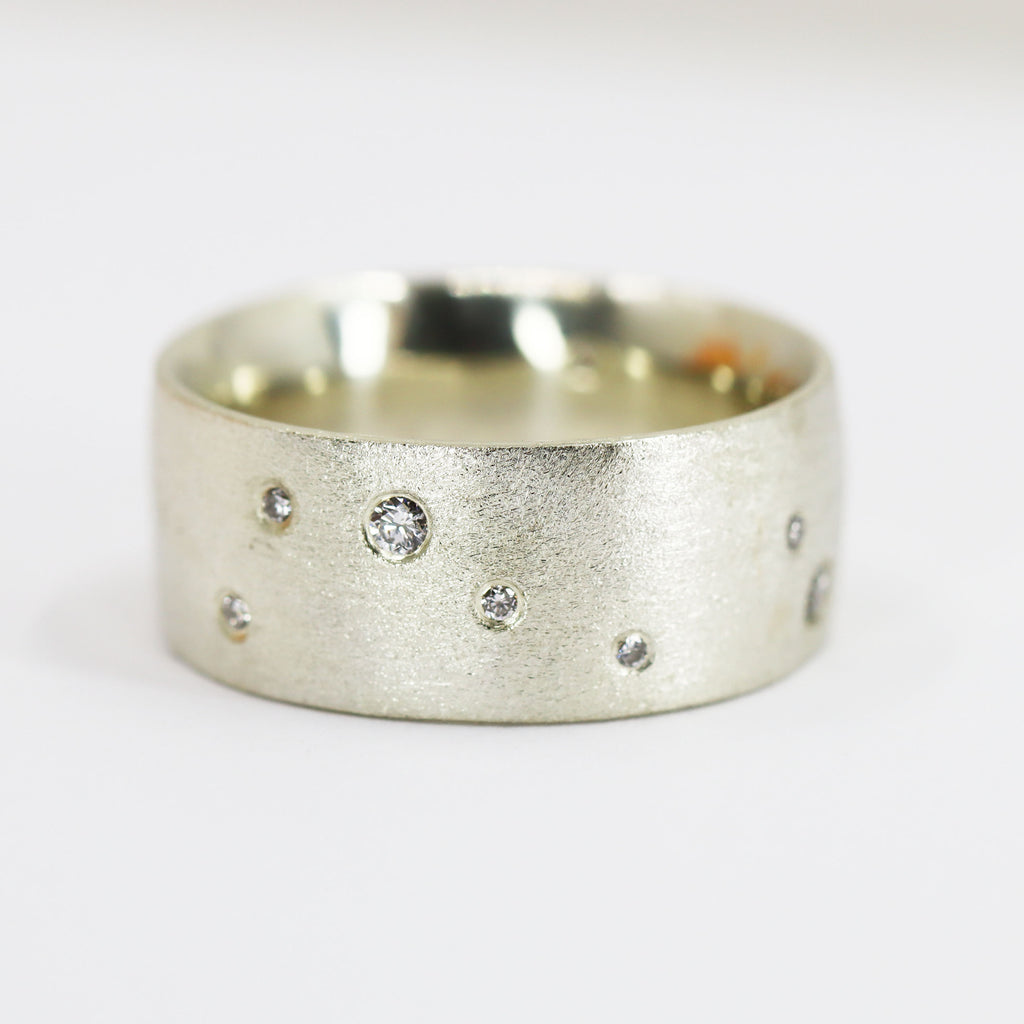 A chunky silver ring with different sized diamonds set into the surface