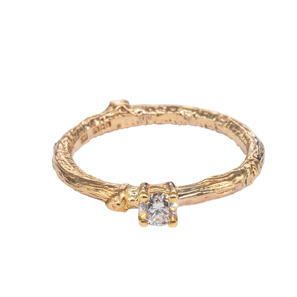 Twig textured gold engagement diamond ring laying down