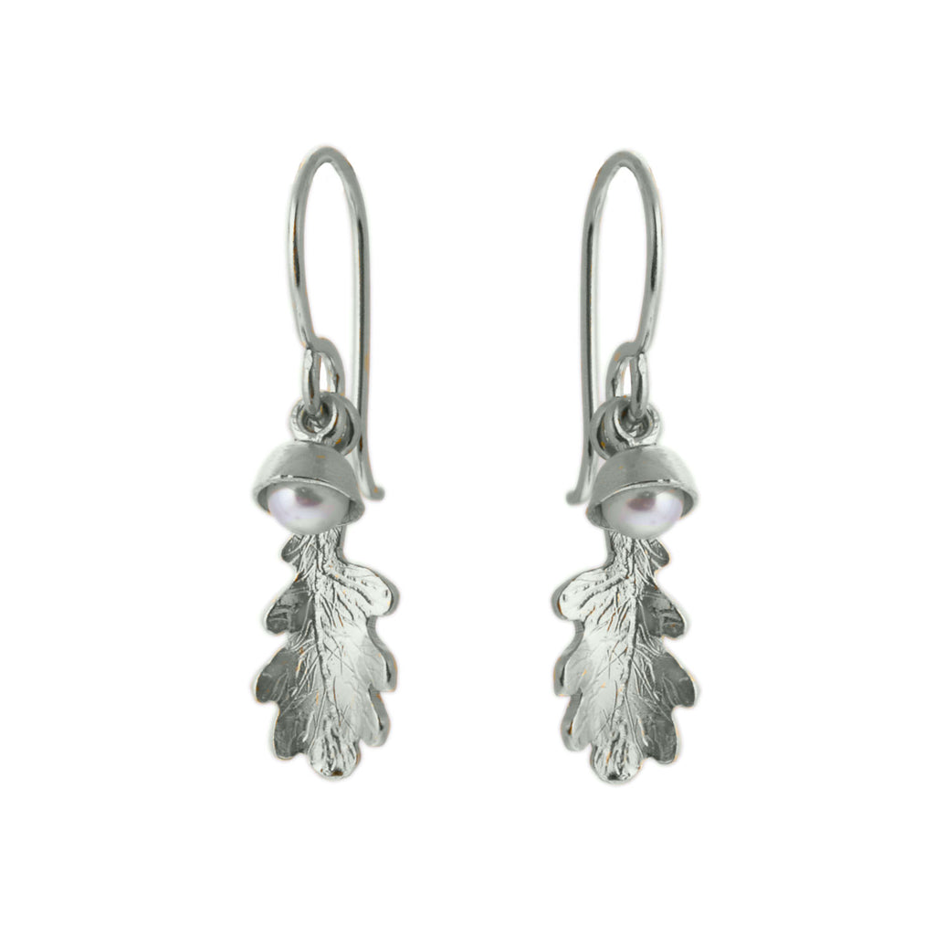 Silver hook earrings with a tiny oak leaf charm and a tiny white pearl in an acorn cup charm