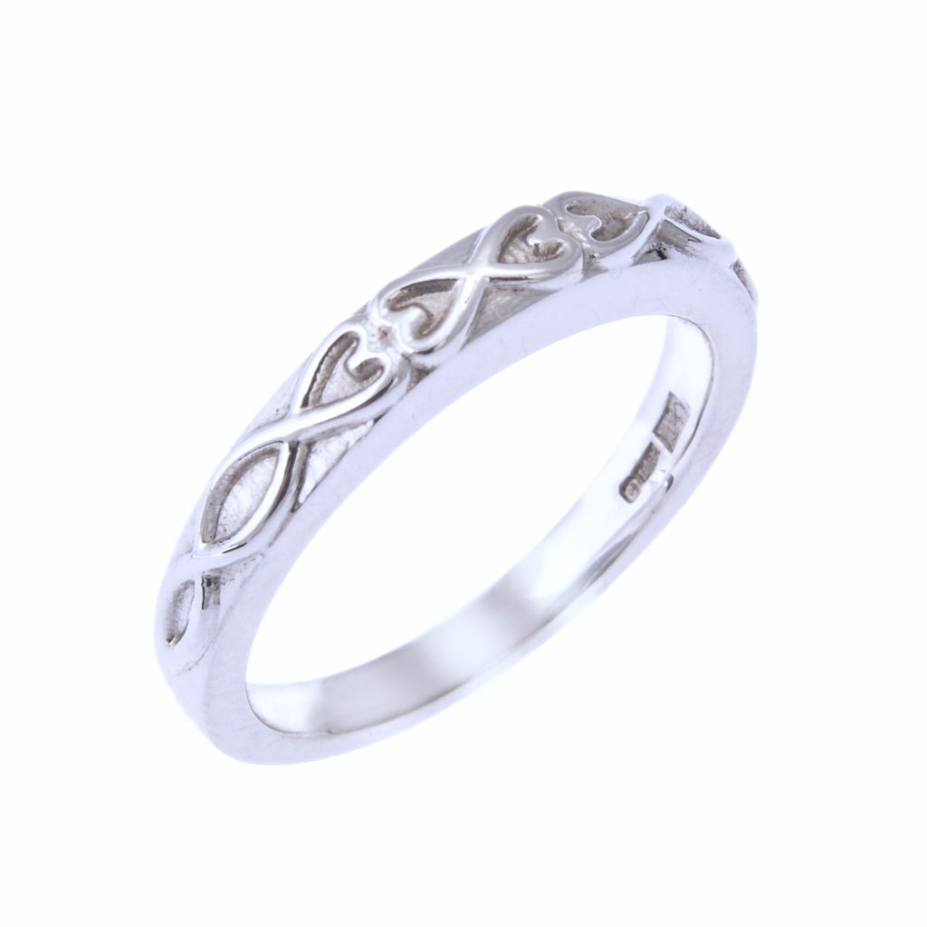 Silver coloured ring standing on end. The ring has a heart and ovals design standing proud from the surface of the ring