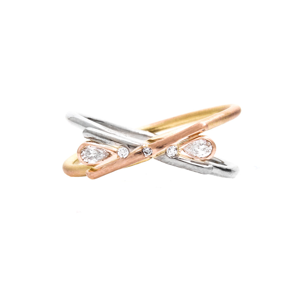 Front of an engagement ring with intersecting white and rose gold wires and 2 pear shaped diamonds