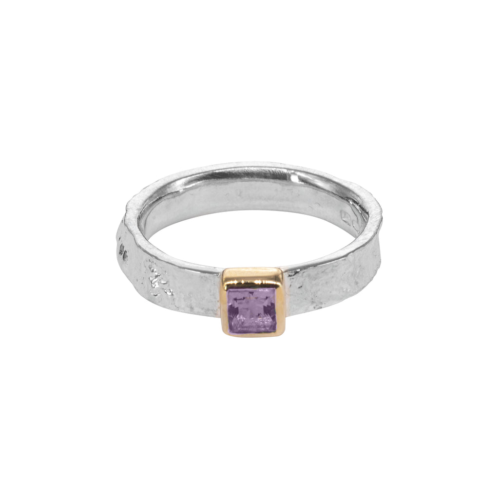 Silver ring with purple square stone at front in gold setting