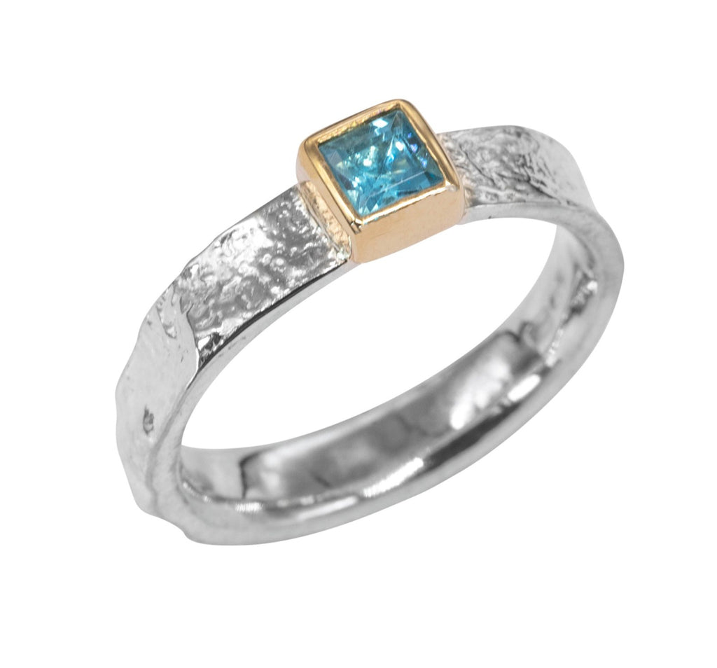Textured silver ring with blue topaz in square gold setting