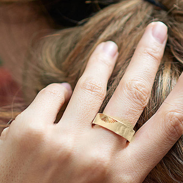 6mm 9ct yellow gold Sunrise wedding ring on woman's hand