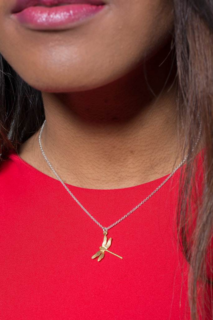 Girl wearing a gold dragonfly necklace