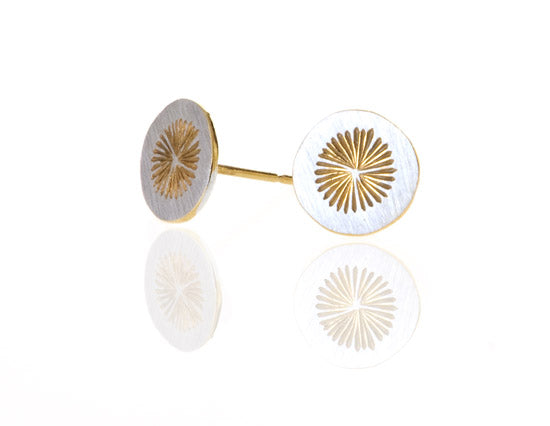Round silver earrings with gold sun design in middle