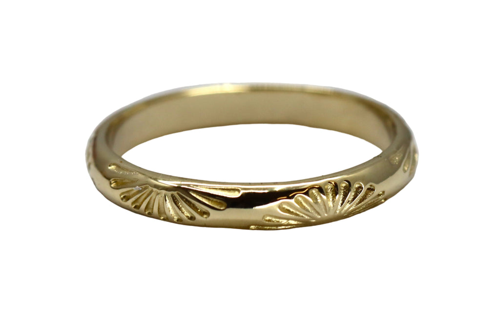 Gold ring with sun patterns on a white background