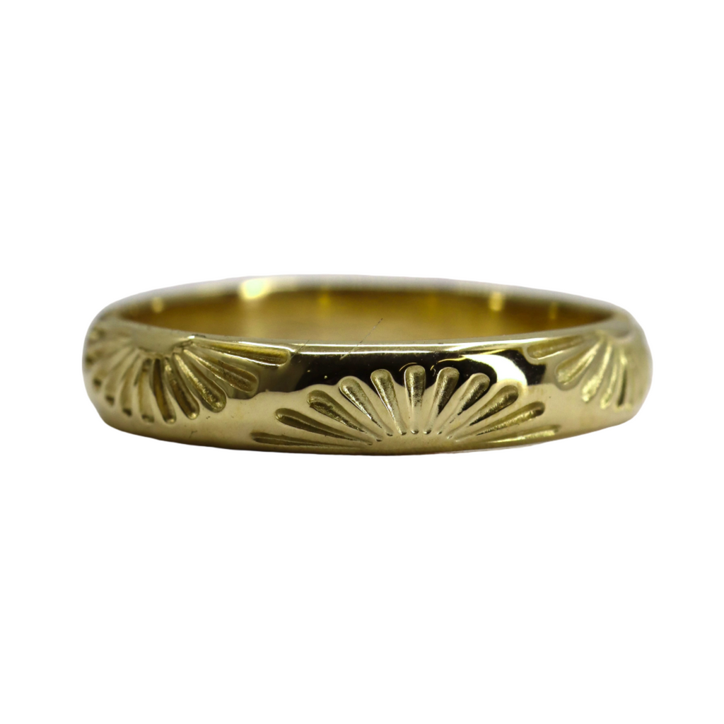 Gold ring with decorative design on a white background