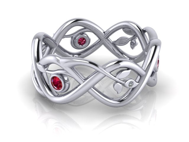 A white gold wedding ring with entwined branches with little leaves at the end. Tiny diamonds are set in some of the leaves. Round rubies are set between some of the branches