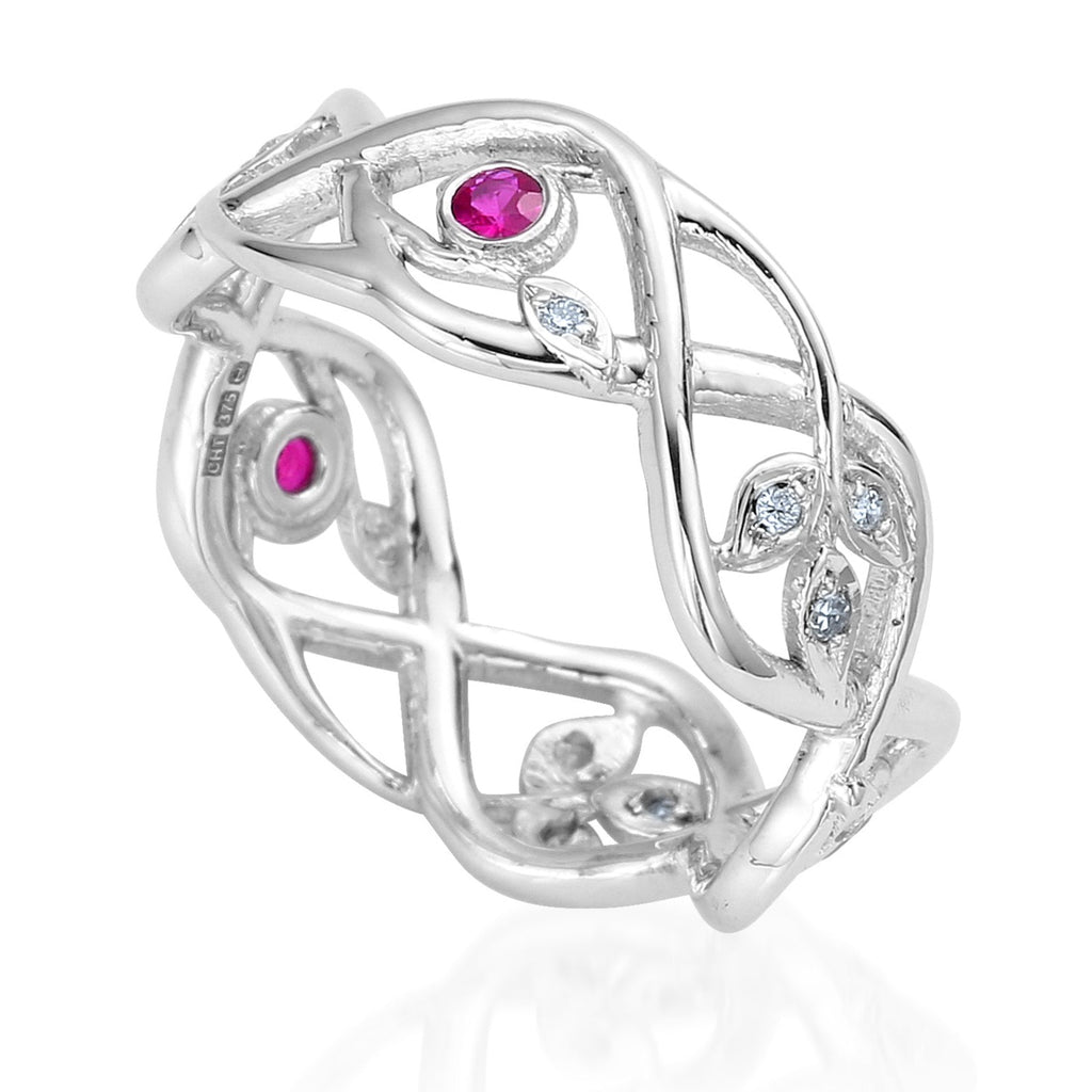 Organic style white gold wedding ring with 2 branches weaving in and out and 3 little leaves on the end of each branch. Tiny diamonds are set into each leaf. Round rubies are set between some of the branches