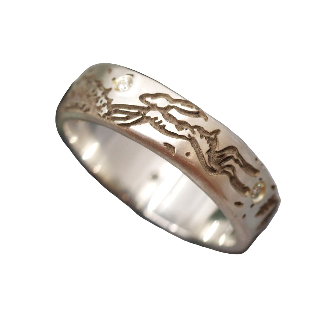 Silver ring with etched rabbit design on white background