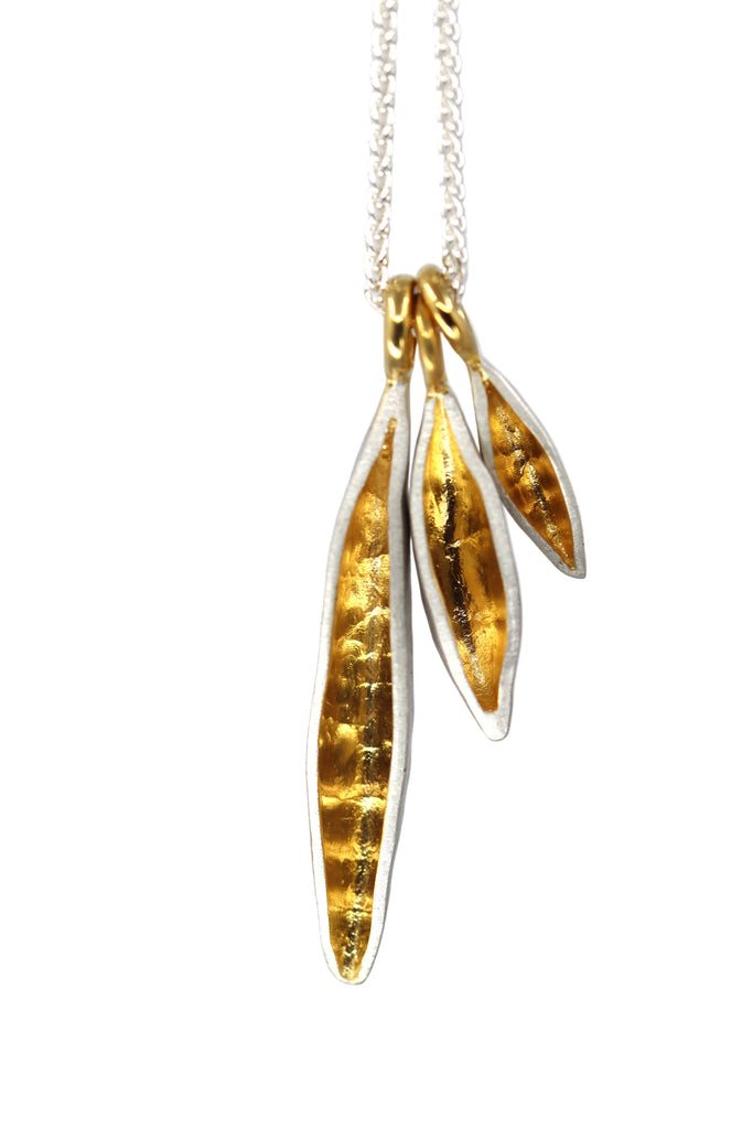 Gold leaf-shaped pendant on a chain against a white background