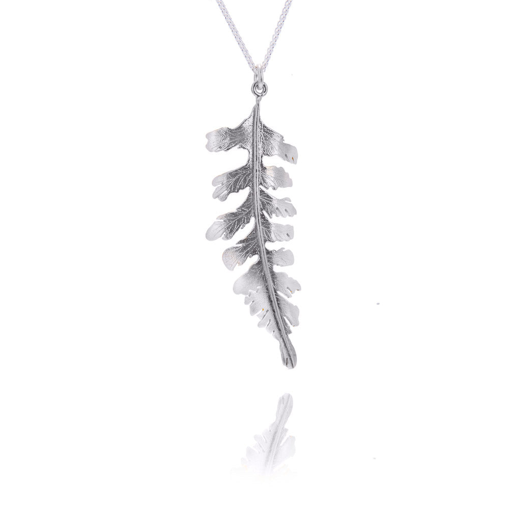 A large silver fern pendant on a silver chain