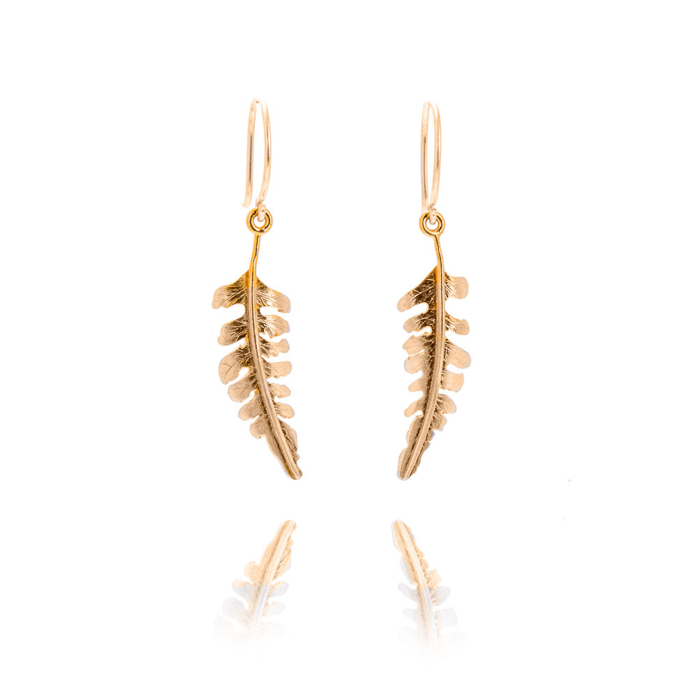 A pair of curved gold fern shaped earrings. The earrings curve in towards each other and hang from gold hook fittings