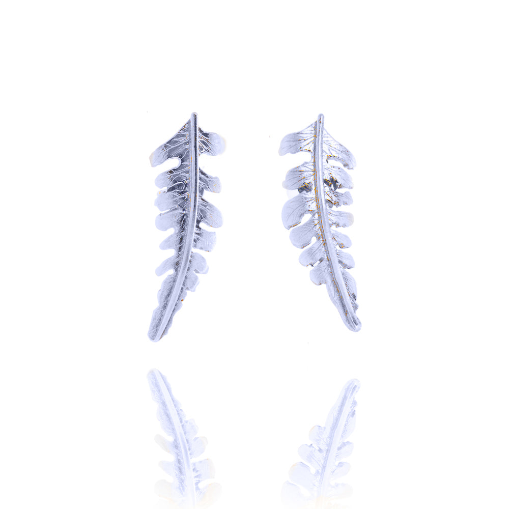 A pair of small silver fern shaped stud earrings. The ferns curve away from each other