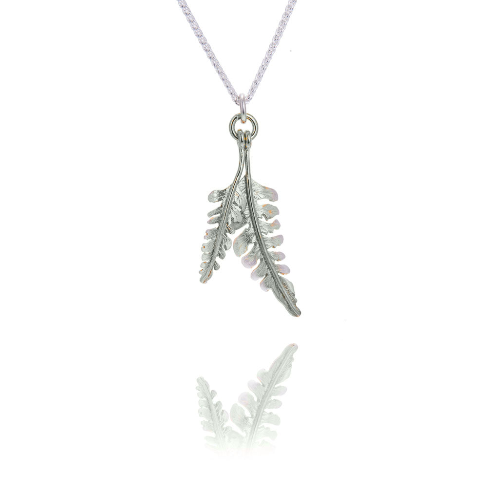 A tiny and a small fern shaped pendant on a silver chain