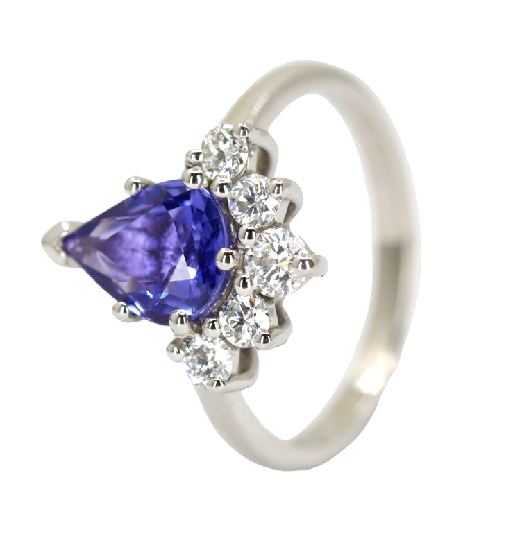 Pear shaped purple stone engagement ring with diamonds around the bottom