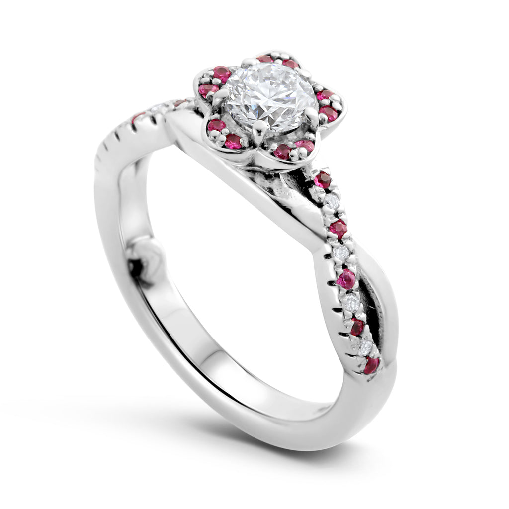 A white gold flower shaped engagement ring with diamonds and pink sapphires