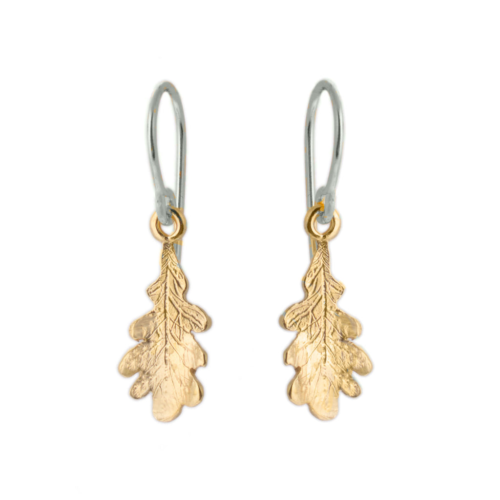Silver hook earrings with a tiny gold oak leaf hanging from each