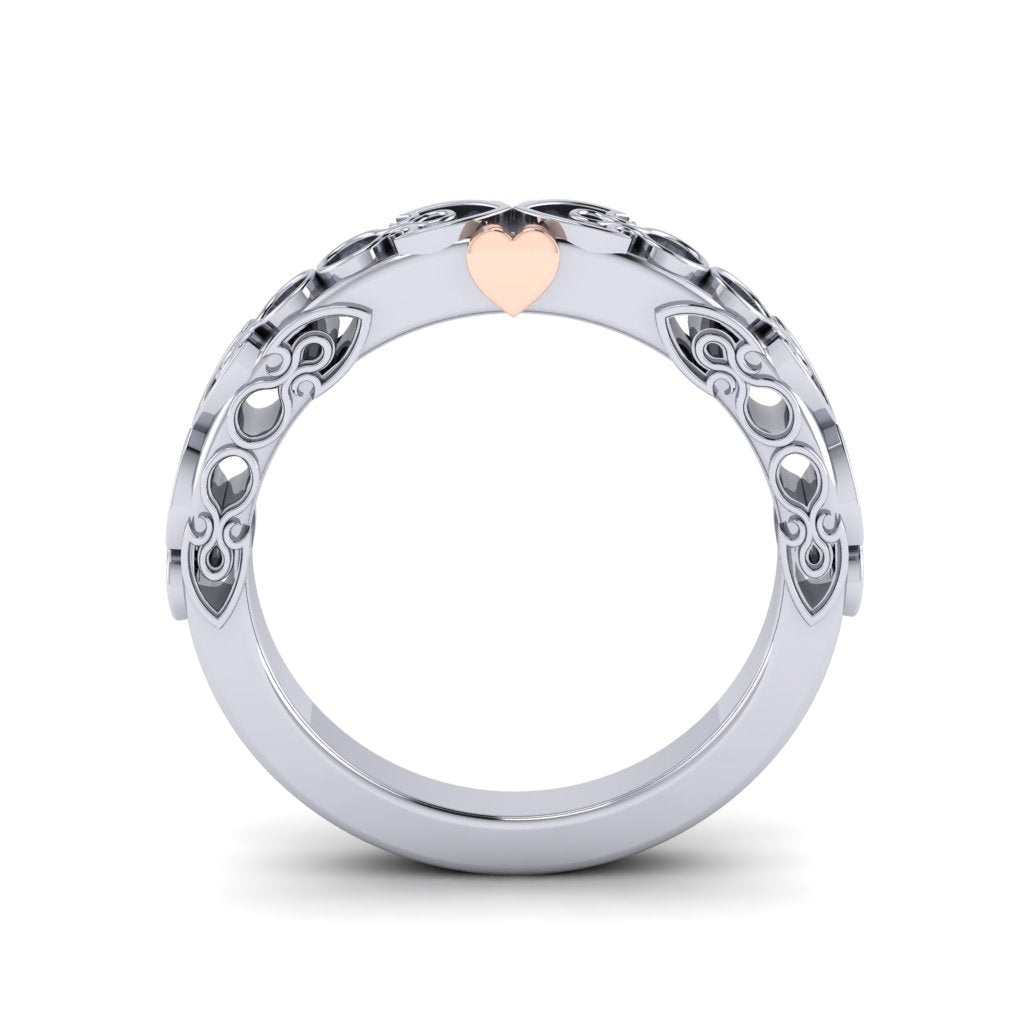 A platinum wedding band standing on end and viewed from the side. It has circular cut outs on the sides which we can see all the way through to the white background.