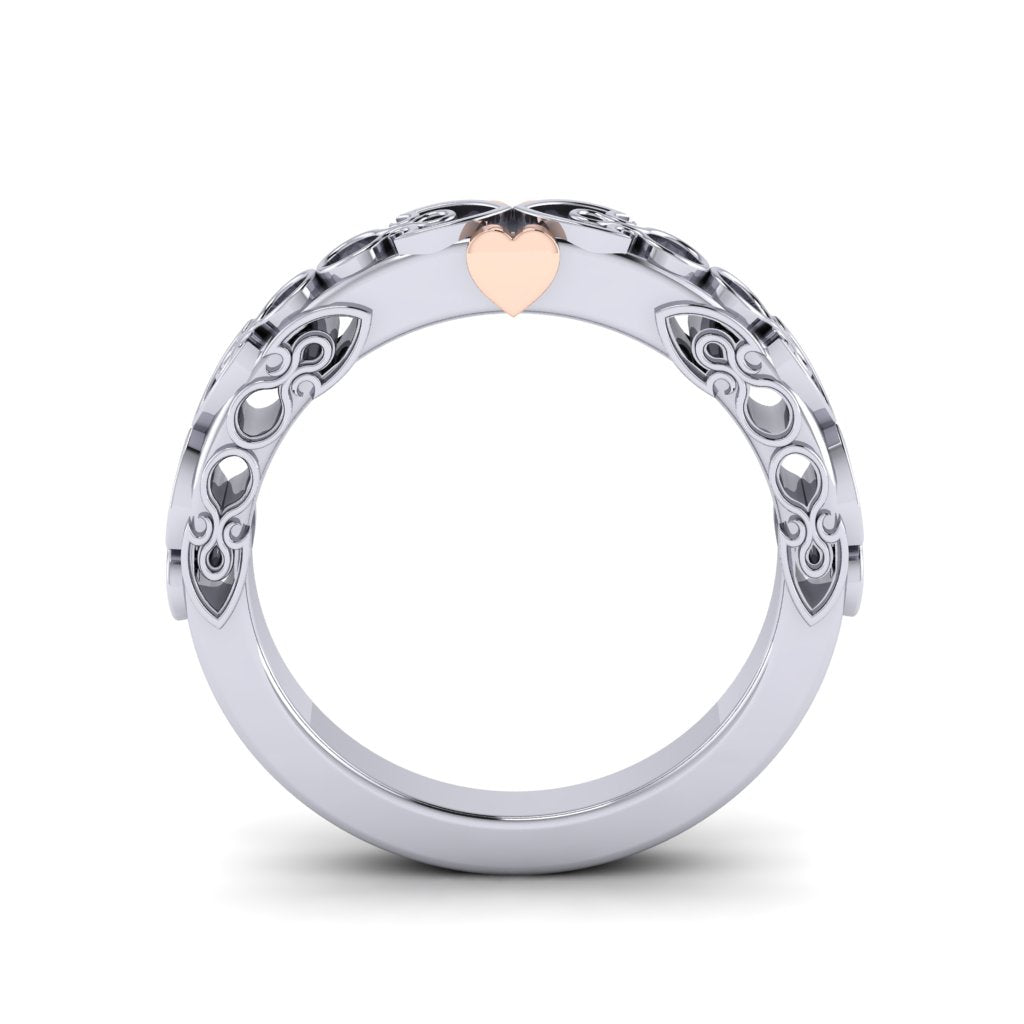 A platinum wedding band standing on end and viewed from the side. It has circular cut outs on the sides which we can see all the way through to the white background.