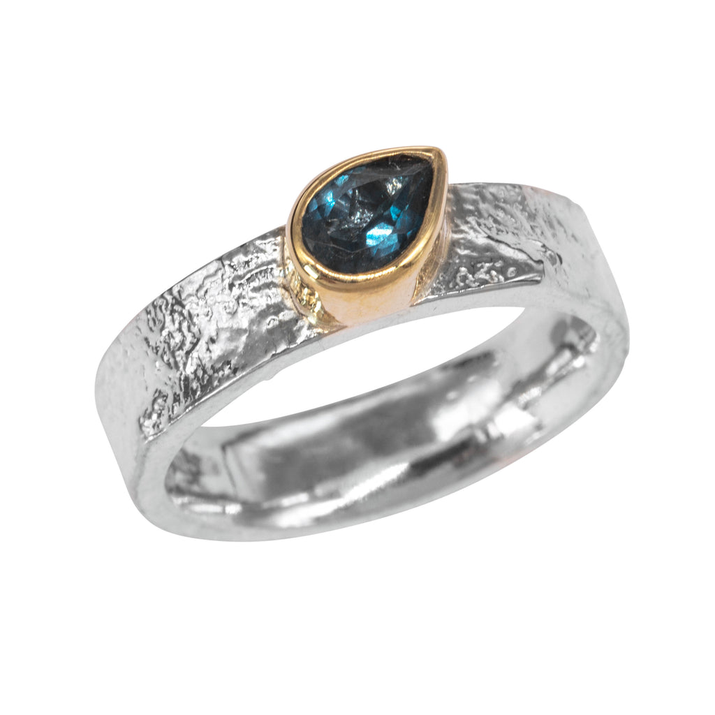Textured silver ring with pear blue stone in smooth gold setting