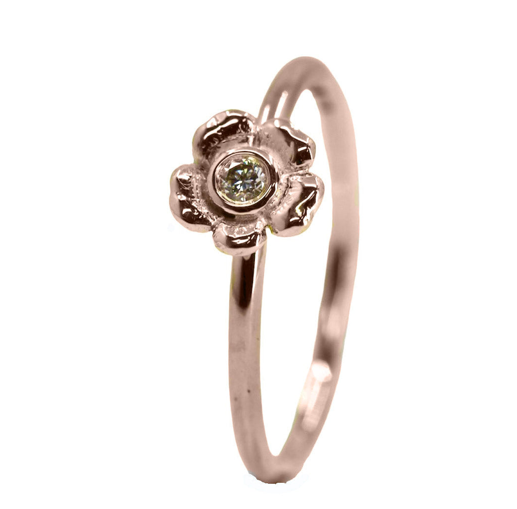 9ct gold ring standing on end with a flower to the front and a diamond in the centre