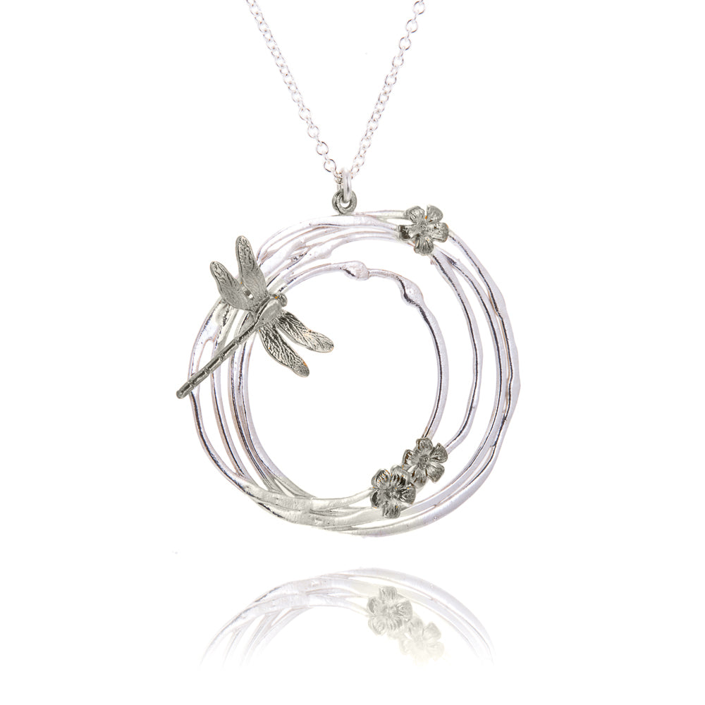 large silver circle necklace with dragonfly and flowers