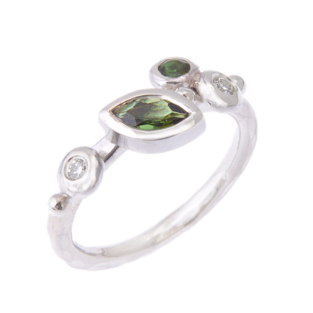 Silver ring with a marquise green stone on an angle plus a round green stone and 2 diamonds in little buds