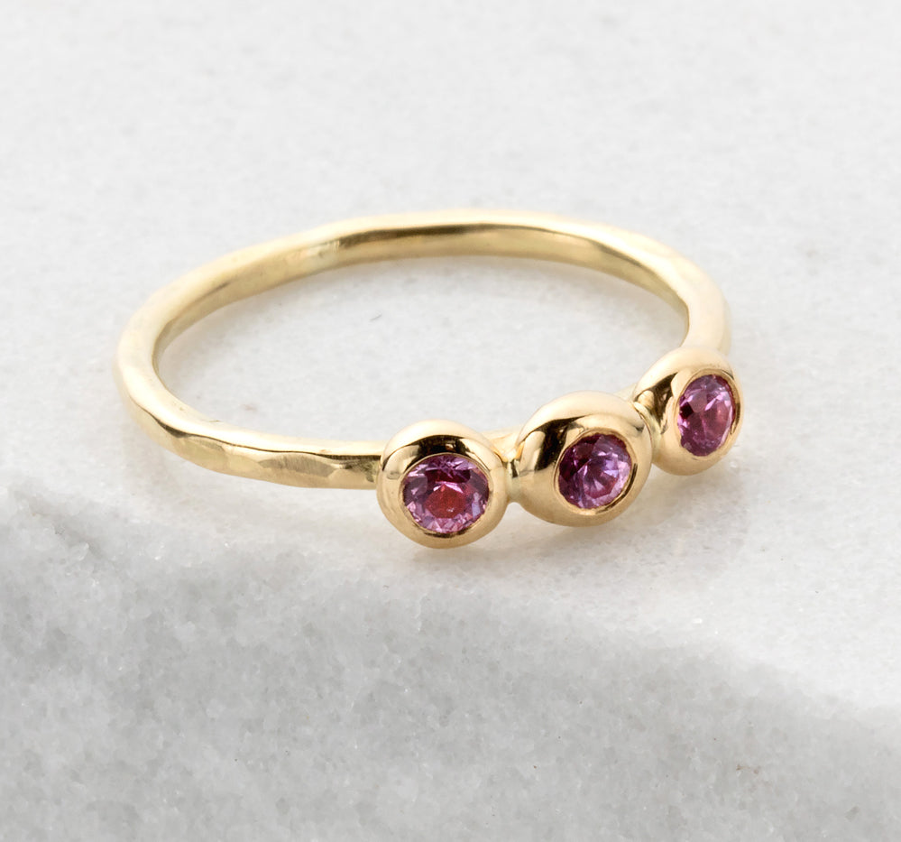 Slim gold ring with 3 pink sapphires encased in gold