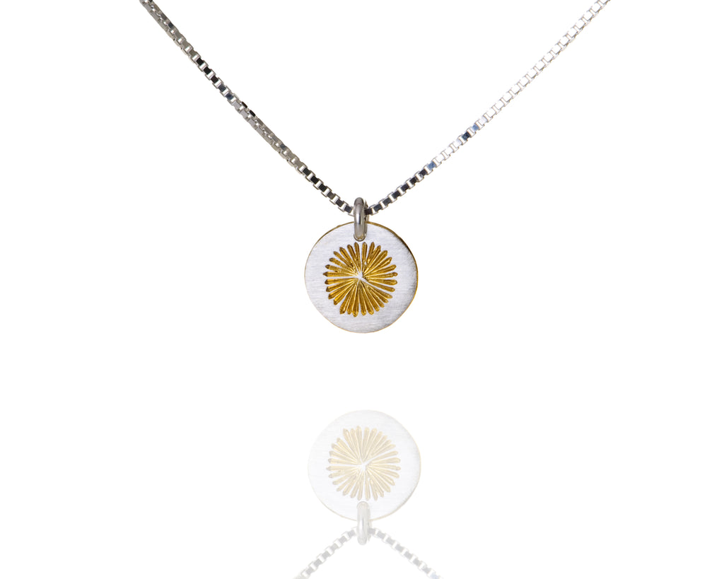Round silver pendant with sun pattern on silver chain