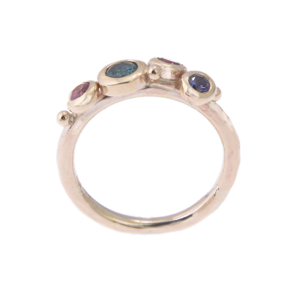 Gold ring with teal, pink and blue gemstones side view