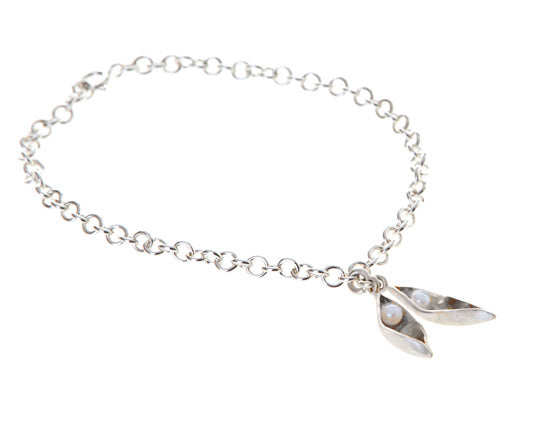 silver charm bracelet with two pods containing white pearls