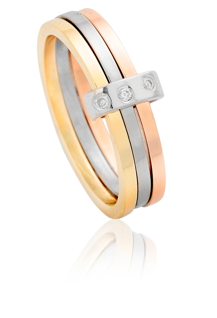 A slim red gold ring, white gold ring and yellow gold ring joined by a white gold diamond set band