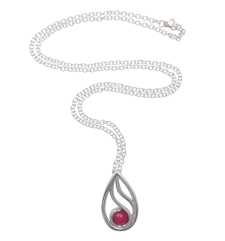 Silver necklace with a teardrop shaped pendant holding a cabochon piece of coral