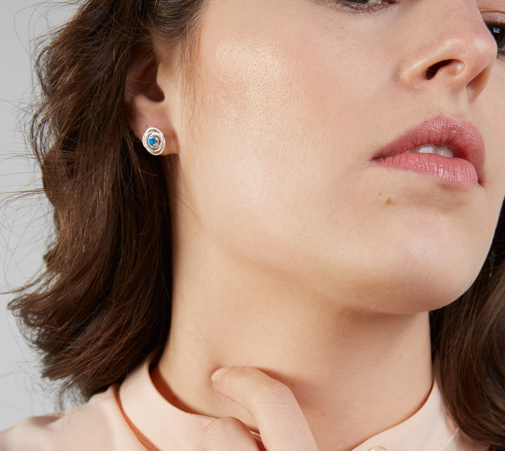 model wearing silver and blue topaz stud earrings