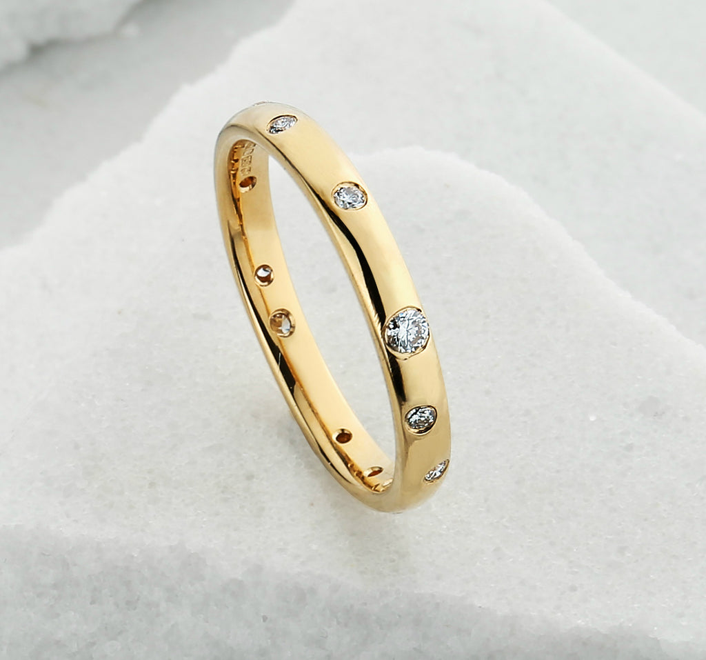 Yellow gold wedding ring with white diamonds scatter set around the band