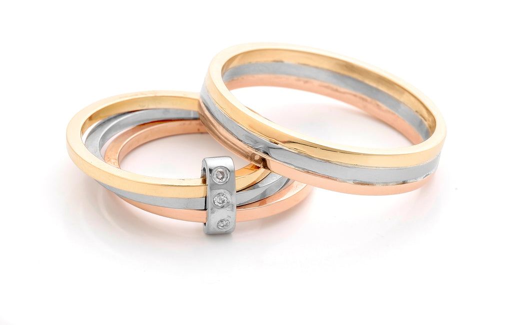 2 rings in yellow, white and red gold. 1 is loosely joined with a diamond band at the front